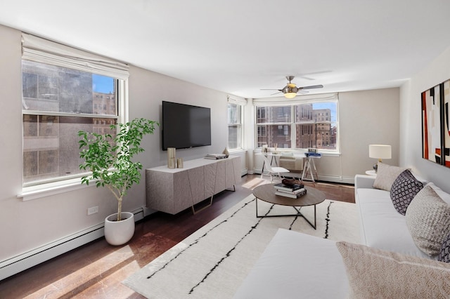 living room featuring baseboard heating, wood finished floors, healthy amount of natural light, and ceiling fan