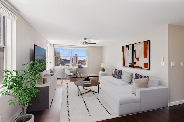 living area featuring wood finished floors, ceiling fan, and baseboards