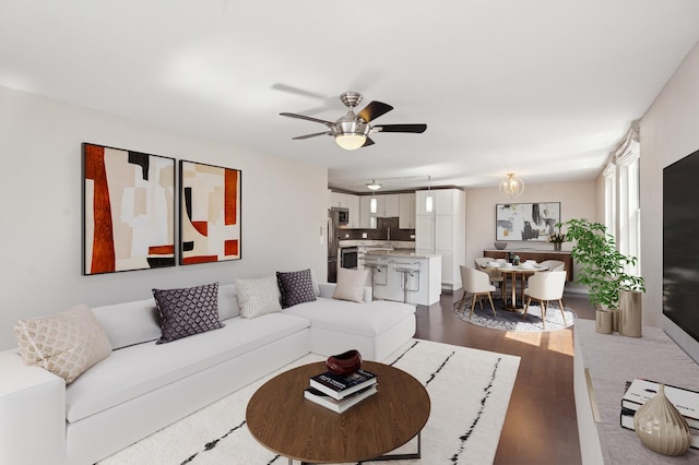 living area featuring dark wood-type flooring and ceiling fan