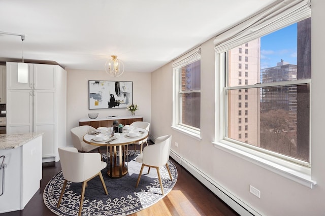dining room with baseboard heating, dark wood finished floors, baseboards, and a chandelier