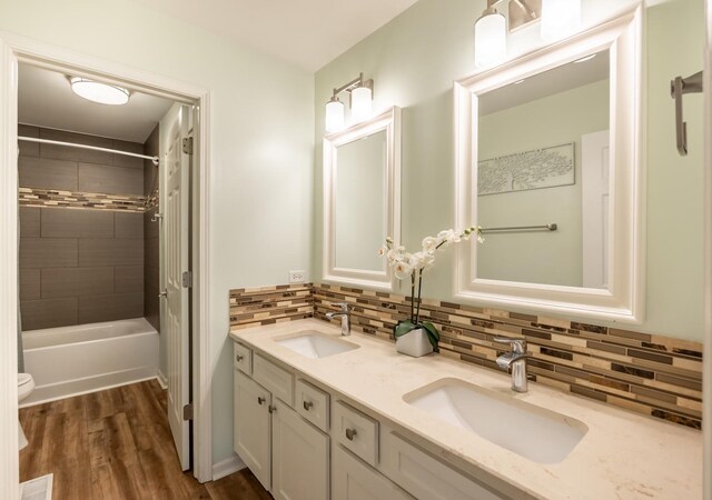3080 Wickenden Ave, Elgin, IL 60124 - bathroom featuring tasteful backsplash, double vanity, wood finished floors, toilet, and bathing tub / shower combination