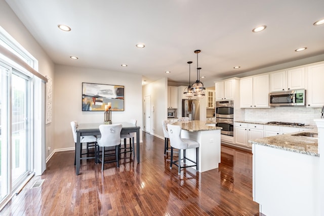 3080 Wickenden Ave, Elgin, IL 60124 - kitchen featuring stainless steel appliances, dark wood-type flooring, light stone counters, tasteful backsplash, and recessed lighting
