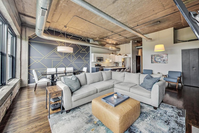 living area featuring wood finished floors and an accent wall