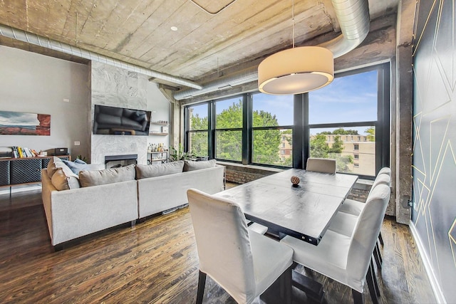 dining room featuring wood finished floors and a tile fireplace