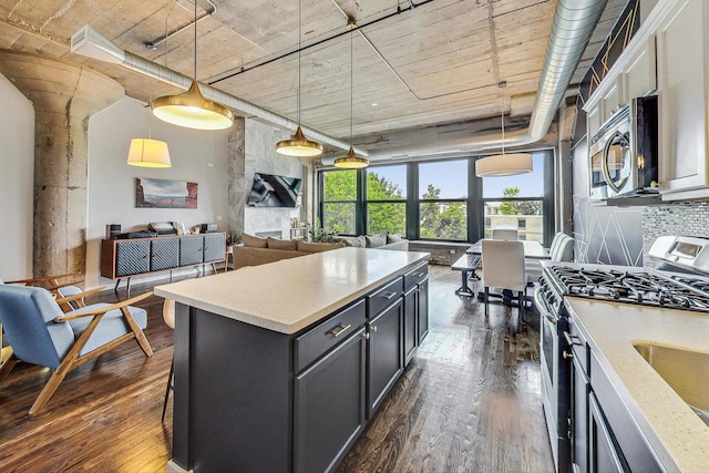 kitchen featuring stainless steel appliances, dark wood-type flooring, open floor plan, pendant lighting, and a kitchen island