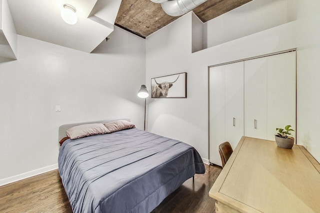 bedroom featuring wood finished floors, baseboards, and a closet