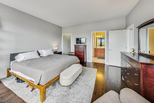 bedroom featuring dark wood-style flooring, baseboards, and ensuite bathroom