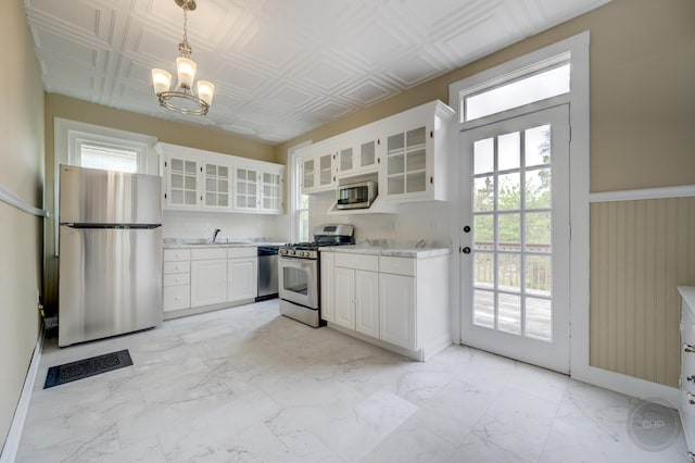 125 Arbor Ave, West Chicago, IL 60185 - kitchen with appliances with stainless steel finishes, light countertops, a chandelier, a sink, and white cabinets