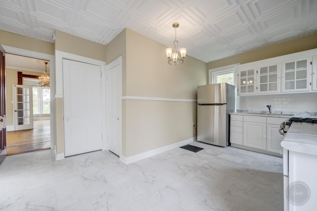 125 Arbor Ave, West Chicago, IL 60185 - kitchen featuring a chandelier, appliances with stainless steel finishes, a sink, light countertops, and white cabinets