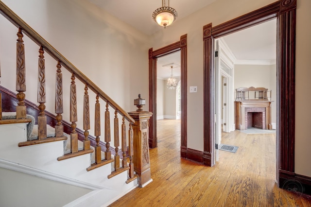 125 Arbor Ave, West Chicago, IL 60185 - entryway featuring a chandelier, wood finished floors, stairway, baseboards, and a fireplace