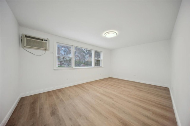 6357 W Addison St Unit Gse, Chicago, IL 60634 - empty room featuring a wall mounted AC, light wood finished floors, and baseboards