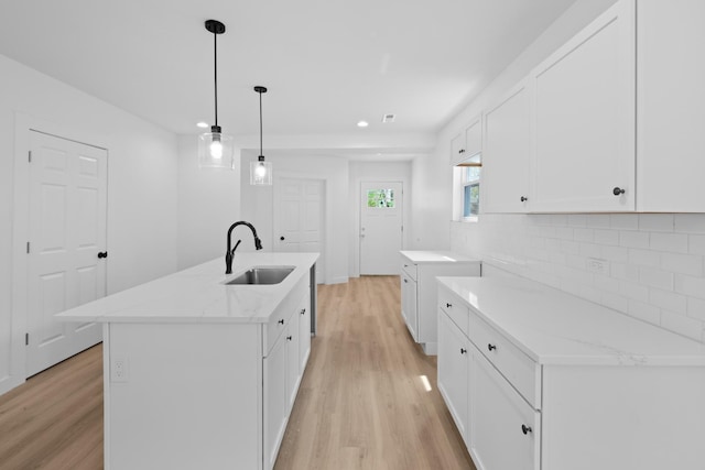 8317 S Constance Ave, Chicago, IL 60617 - kitchen featuring a sink, light wood-style flooring, tasteful backsplash, white cabinets, and light stone countertops