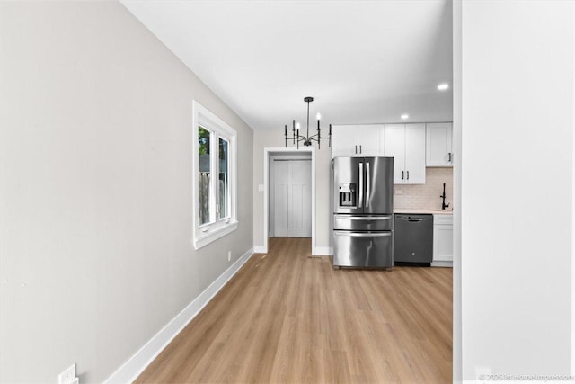266 Merrill Ave, Calumet City, IL 60409 - kitchen with dishwashing machine, stainless steel refrigerator with ice dispenser, light wood-type flooring, baseboards, and a chandelier