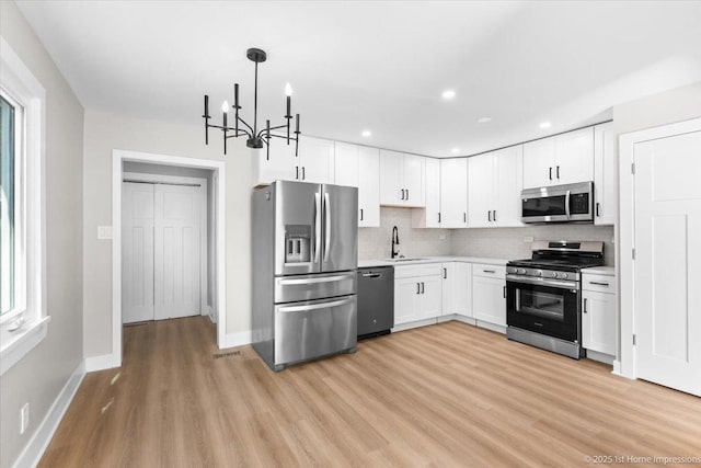 266 Merrill Ave, Calumet City, IL 60409 - kitchen with stainless steel appliances, a sink, light countertops, light wood-style flooring, and white cabinetry