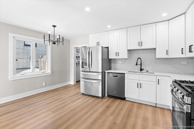 266 Merrill Ave, Calumet City, IL 60409 - kitchen with stainless steel appliances, a sink, a chandelier, light countertops, and baseboards