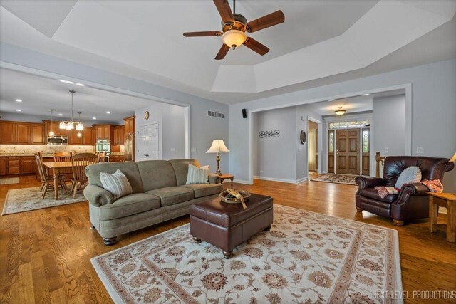 1123 Redbud Ln, Sugar Grove, IL 60554 - living area with a ceiling fan, light wood-style flooring, a tray ceiling, recessed lighting, and a chandelier