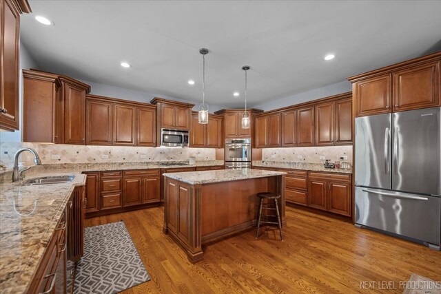 1123 Redbud Ln, Sugar Grove, IL 60554 - kitchen with stainless steel appliances, a sink, brown cabinetry, a center island, and recessed lighting