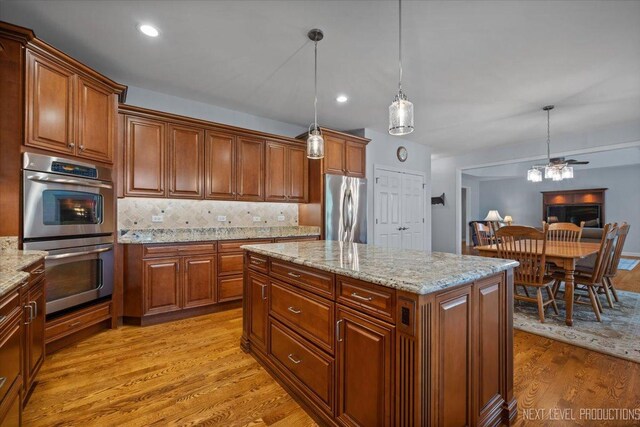 1123 Redbud Ln, Sugar Grove, IL 60554 - kitchen with appliances with stainless steel finishes, light wood-style flooring, decorative light fixtures, backsplash, and light stone counters