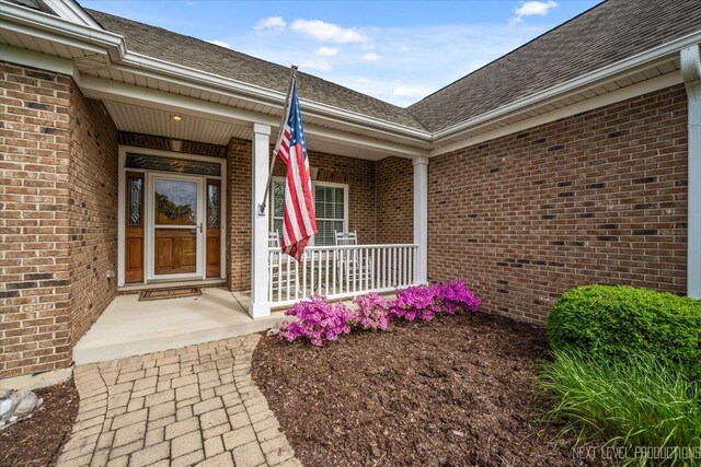 1123 Redbud Ln, Sugar Grove, IL 60554 - property entrance with brick siding, covered porch, and roof with shingles