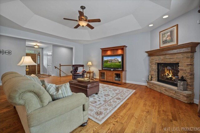 1123 Redbud Ln, Sugar Grove, IL 60554 - living area featuring ceiling fan, a tray ceiling, a fireplace, baseboards, and wood finished floors