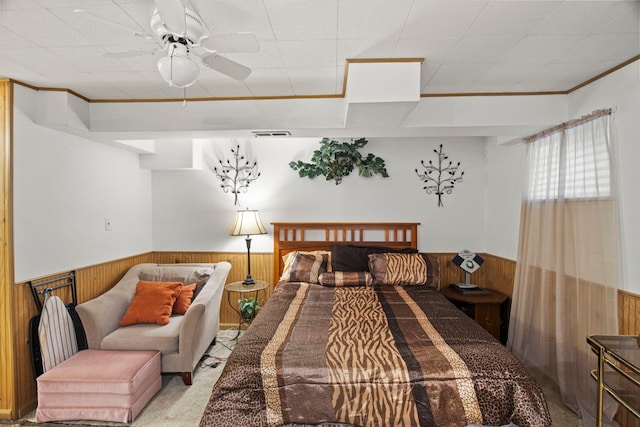 21220 Silktree Cir, Plainfield, IL 60544 - bedroom with a wainscoted wall, wood walls, crown molding, carpet, and ceiling fan