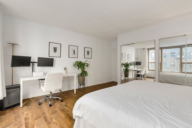 bedroom featuring wood finished floors and an office area