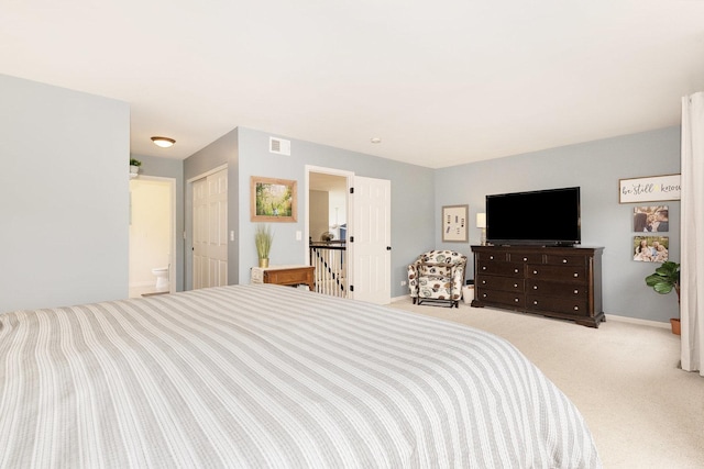 bedroom featuring light colored carpet, baseboards, and connected bathroom
