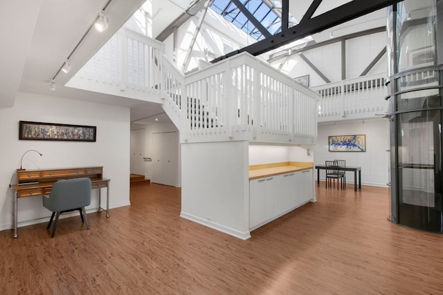 241 E Burlington St Unit C, Riverside, IL 60546 - living area featuring track lighting, wood finished floors, a high ceiling, a skylight, and baseboards