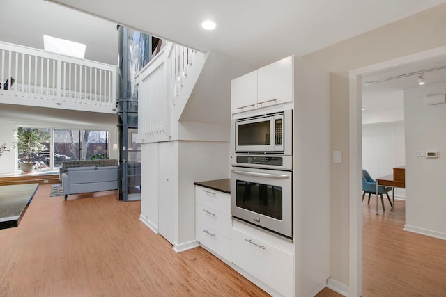 241 E Burlington St Unit C, Riverside, IL 60546 - kitchen featuring stainless steel appliances, light wood-style floors, white cabinetry, baseboards, and recessed lighting