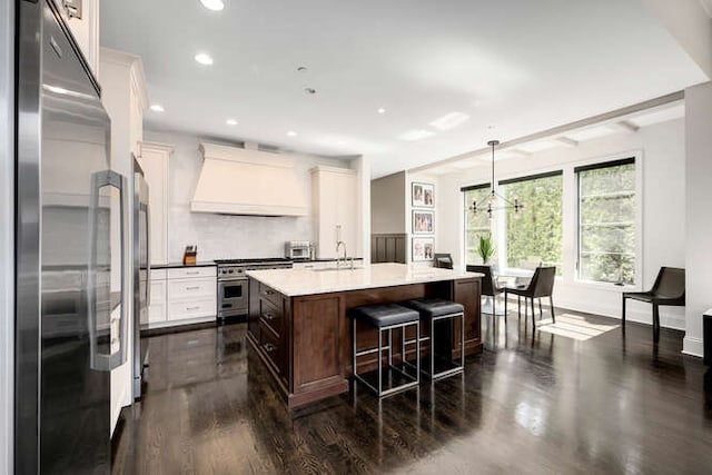 31 Concord Dr, Oak Brook, IL 60523 - kitchen with appliances with stainless steel finishes, premium range hood, dark wood-style flooring, a sink, and a breakfast bar