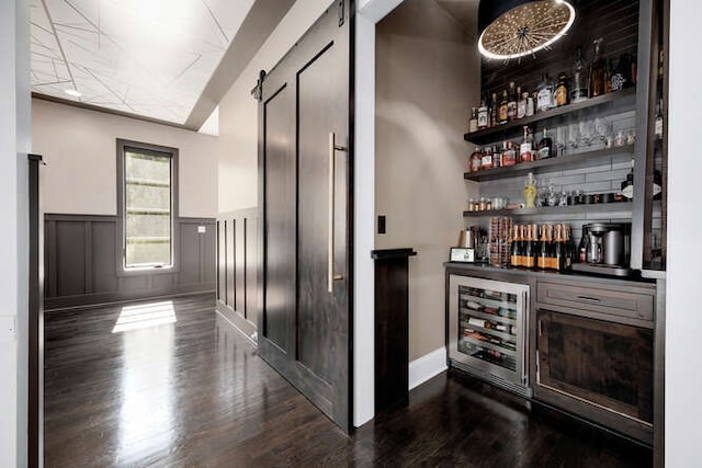 31 Concord Dr, Oak Brook, IL 60523 - indoor dry bar featuring wood finished floors, wainscoting, a barn door, and beverage cooler