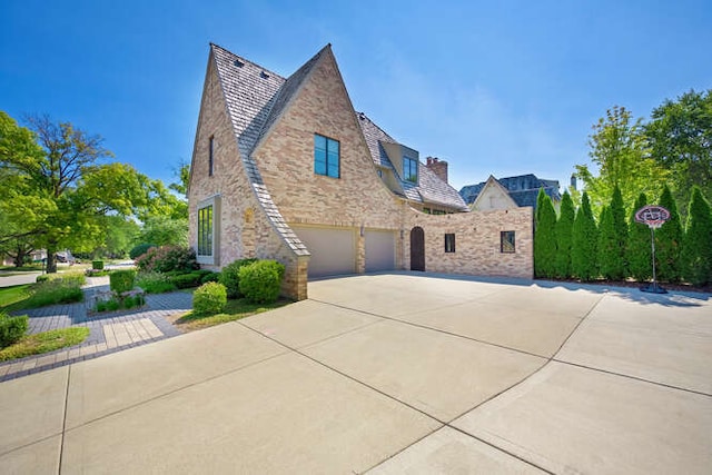 31 Concord Dr, Oak Brook, IL 60523 - view of front of property with stone siding, driveway, an attached garage, and a high end roof