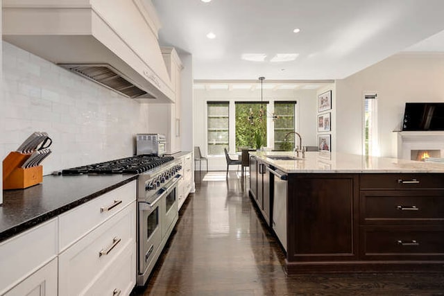 31 Concord Dr, Oak Brook, IL 60523 - kitchen with a sink, stainless steel appliances, premium range hood, dark brown cabinetry, and decorative backsplash