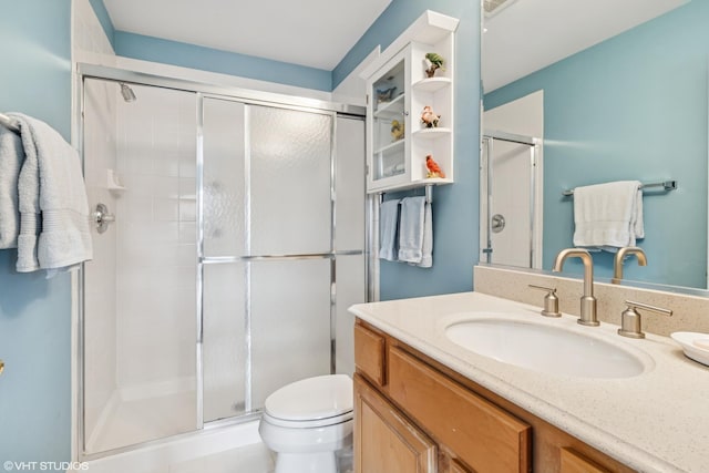 full bath featuring a stall shower, toilet, and vanity