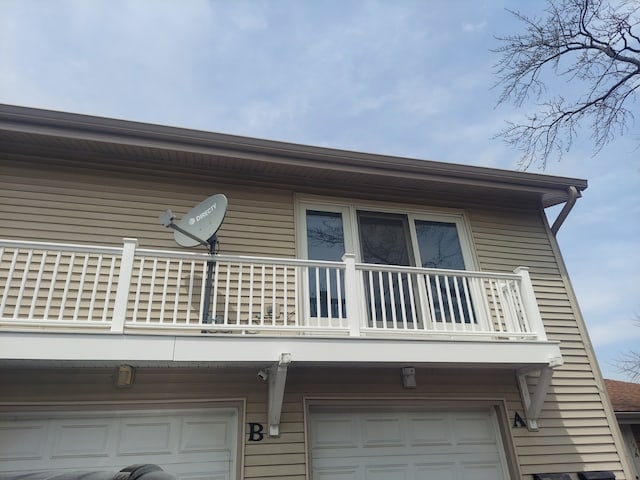back of property featuring a balcony and an attached garage