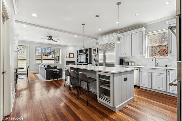 4845 N Bell Ave, Chicago, IL 60625 - kitchen with stainless steel appliances, a sink, dark wood finished floors, a breakfast bar area, and open floor plan