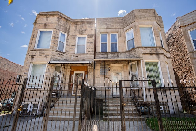 3929 W Arthington St, Chicago, IL 60624 - multi unit property with stone siding, a gate, and a fenced front yard