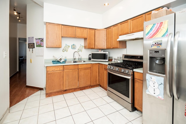 3929 W Arthington St, Chicago, IL 60624 - kitchen featuring appliances with stainless steel finishes, under cabinet range hood, light countertops, a sink, and brown cabinetry