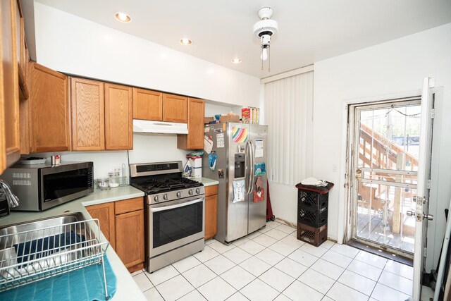 3929 W Arthington St, Chicago, IL 60624 - kitchen with appliances with stainless steel finishes, under cabinet range hood, light countertops, and brown cabinetry