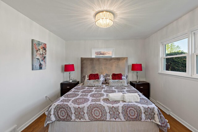 785 E 164th St, South Holland, IL 60473 - bedroom featuring baseboard heating, a chandelier, wood finished floors, and baseboards