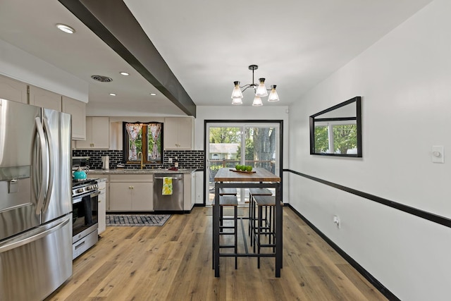 785 E 164th St, South Holland, IL 60473 - kitchen with stainless steel appliances, decorative backsplash, a chandelier, light wood-style flooring, and recessed lighting