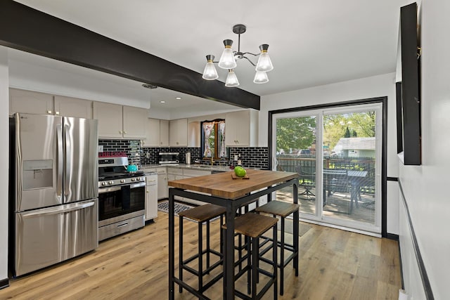 785 E 164th St, South Holland, IL 60473 - kitchen featuring appliances with stainless steel finishes, a chandelier, tasteful backsplash, light wood-style flooring, and recessed lighting