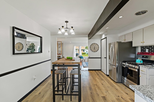 785 E 164th St, South Holland, IL 60473 - kitchen featuring appliances with stainless steel finishes, a chandelier, light wood finished floors, white cabinets, and decorative backsplash