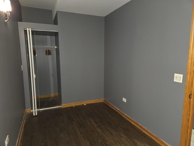 948 N California Ave, Chicago, IL 60622 - unfurnished bedroom with dark wood finished floors, baseboards, and a closet