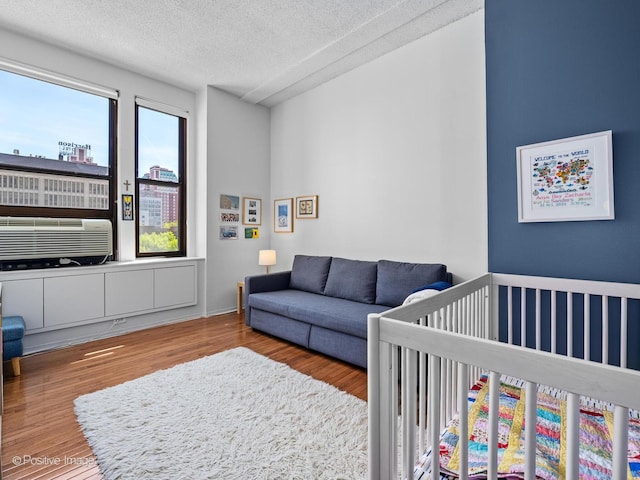 600 S Dearborn St Unit 302, Chicago, IL 60605 - bedroom featuring wood finished floors, a textured ceiling, a nursery area, cooling unit, and a view of city