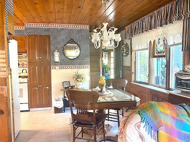 dining space with a chandelier and wood ceiling