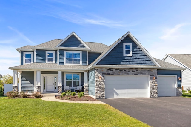 2319 Coventry Cir, Sycamore, IL 60178 - craftsman-style home featuring driveway, an attached garage, a front lawn, covered porch, and stone siding