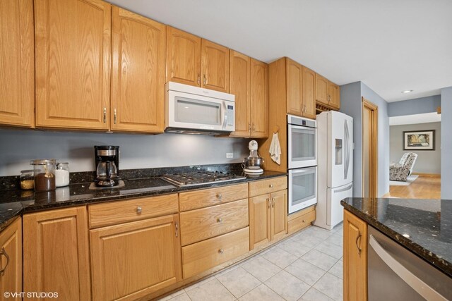18321 Country Ln, Lansing, IL 60438 - kitchen featuring stainless steel appliances, dark stone countertops, light tile patterned floors, and recessed lighting