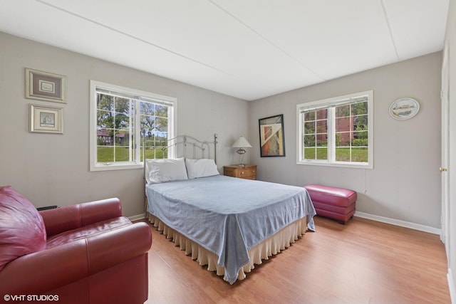 bedroom with wood finished floors and baseboards