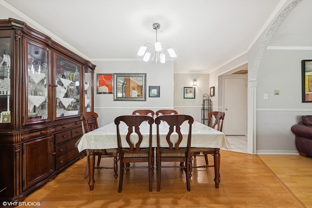 dining space featuring a chandelier, light wood-style flooring, and ornamental molding